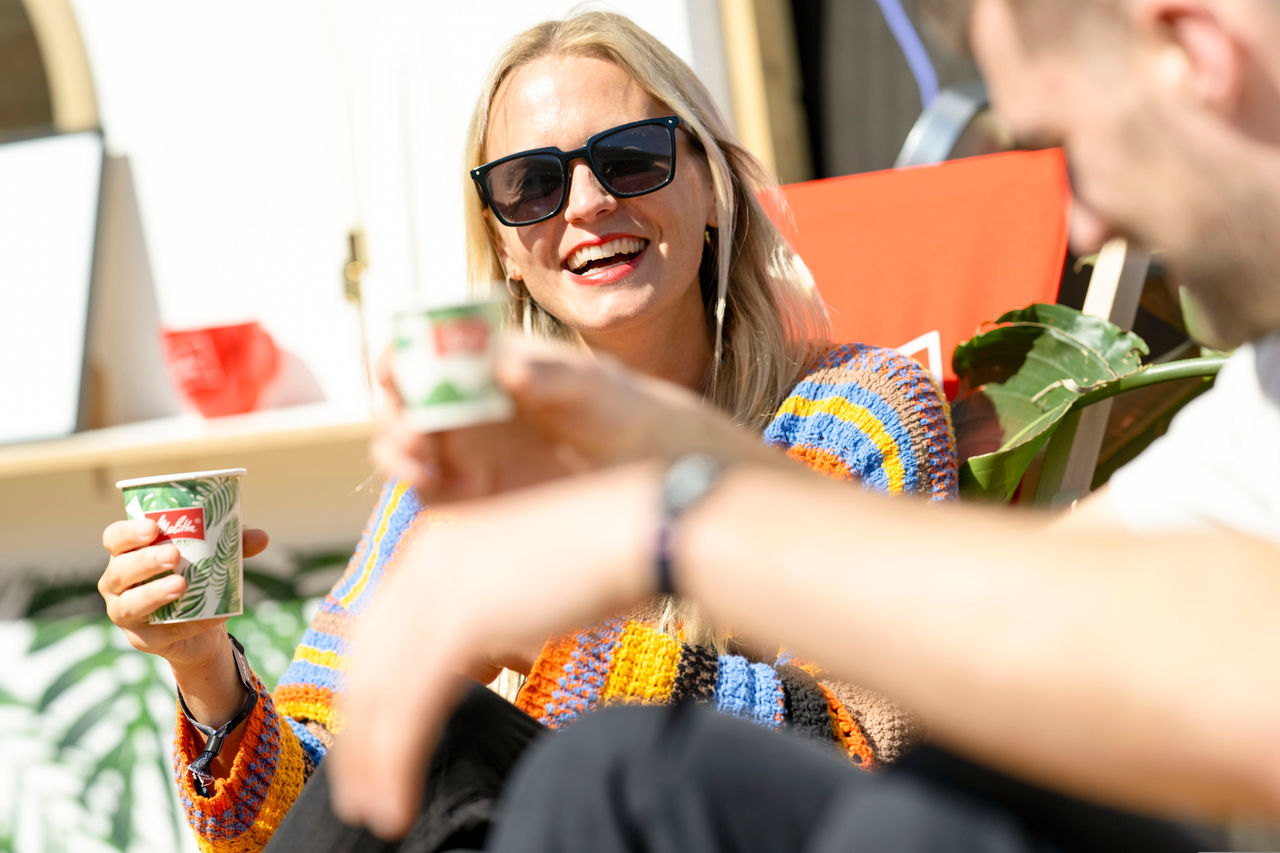 Menschen im Liegestuhl mit Kaffeebecher in der Hand