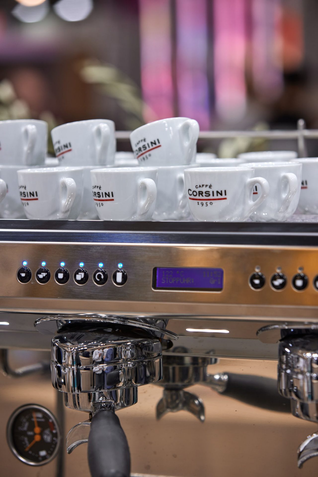 Auf einer Siebträgermaschine stehen Kaffeetassen