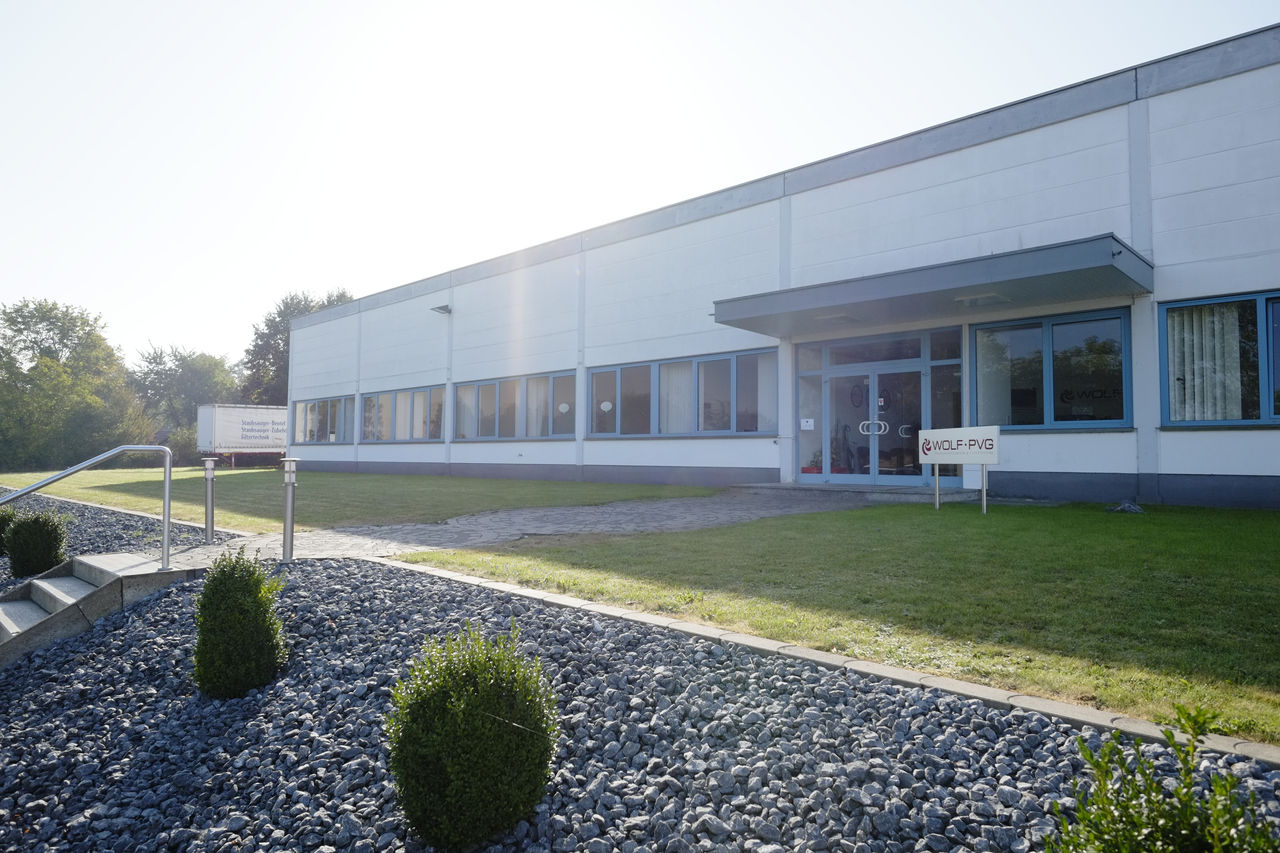 Weißes Bürogebäude mit Flachdach von Wolf PVG im Sonnenschein.